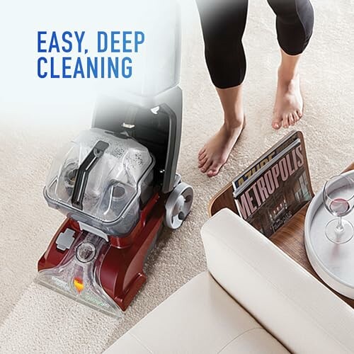 Person using a carpet cleaner on a carpeted floor.