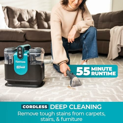 Person using a cordless carpet cleaner on a rug.