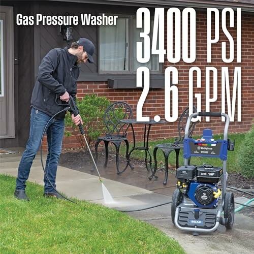 Man using a gas pressure washer on a concrete path.