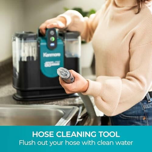 Person using a hose cleaning tool by a sink