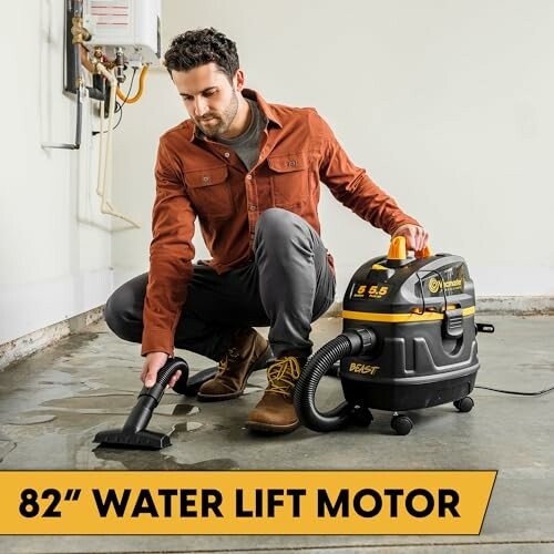 Man using a wet dry vacuum on a wet floor.