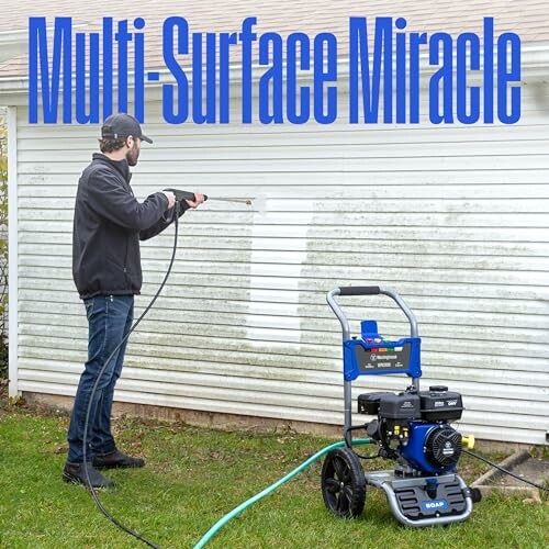 Person using a pressure washer to clean house siding.