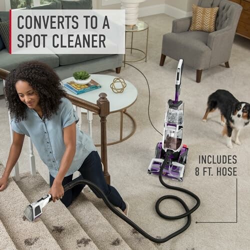 Woman using vacuum spot cleaner on carpet with dog nearby.